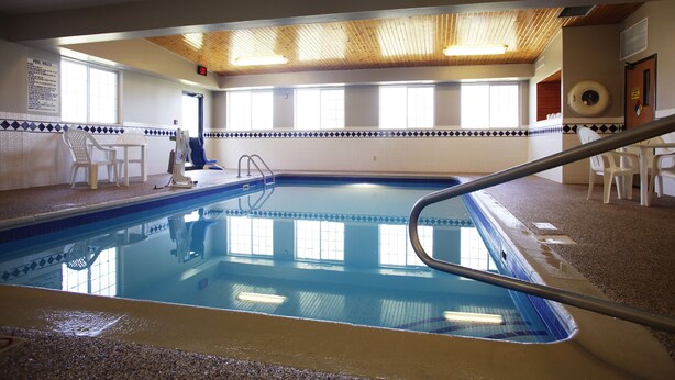 Una piscina interior amb sostre de fusta, parets de rajola i vista clara sobre la zona de la piscina.