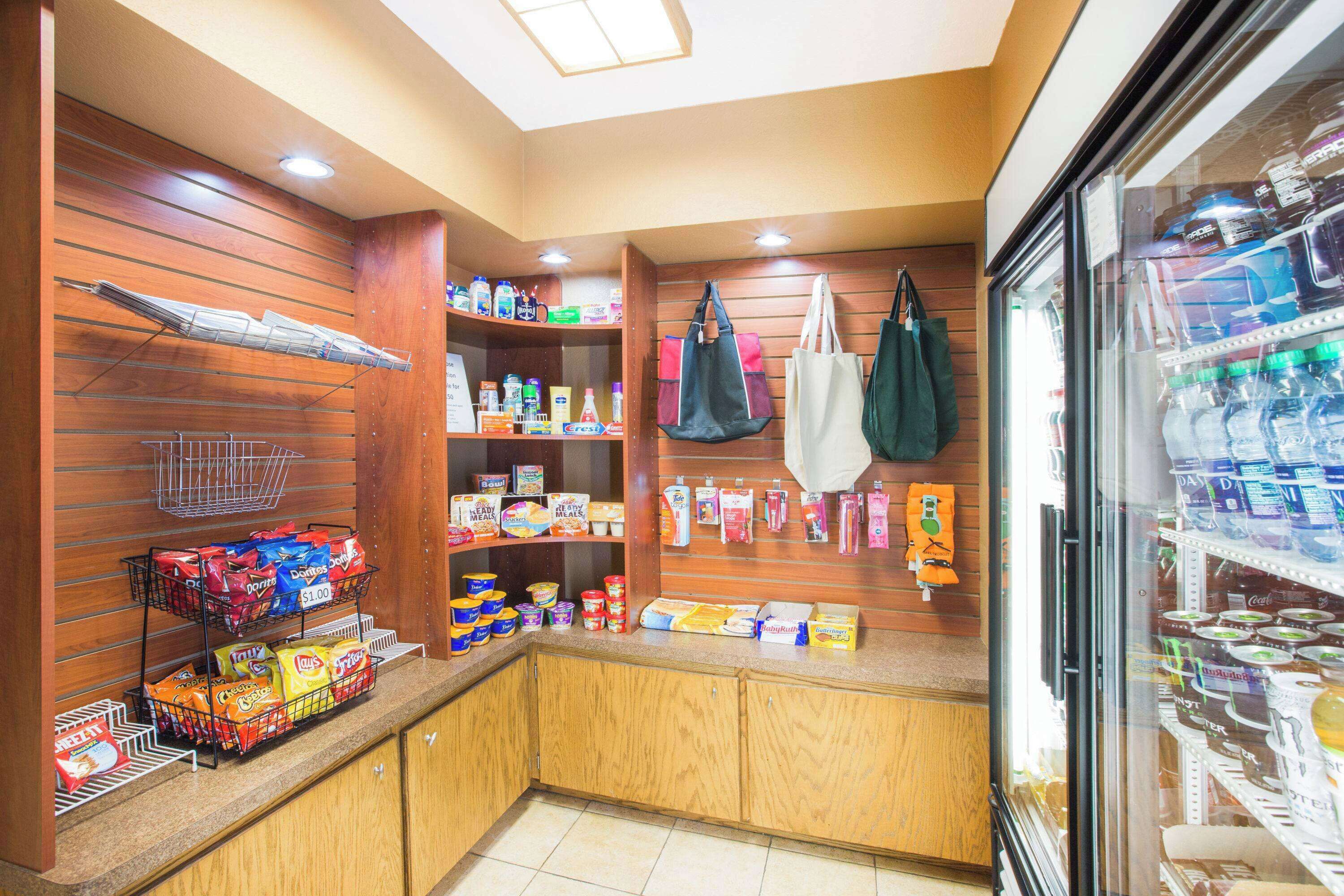 A self-service area with snack dispensers, a refrigerated section, and hanging bags.