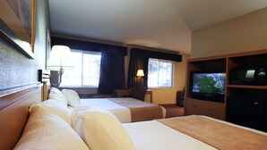 Habitació d'hotel amb dos llits, una televisió, una taula i una cadira.