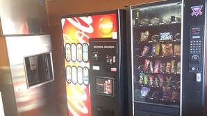 Tres máquinas expendedoras con Coca-Cola y otras bebidas, aperitivos y un panel de botones.