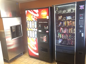 Three vending machines with Coca-Cola and other beverages, snacks, and a push button interface. - Americas Best Value Inn Garden City (Garden City)