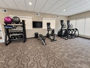 A fitness room with exercise equipment, a television, and a patterned carpet. - Residence Inn by Marriott Davenport (Davenport)