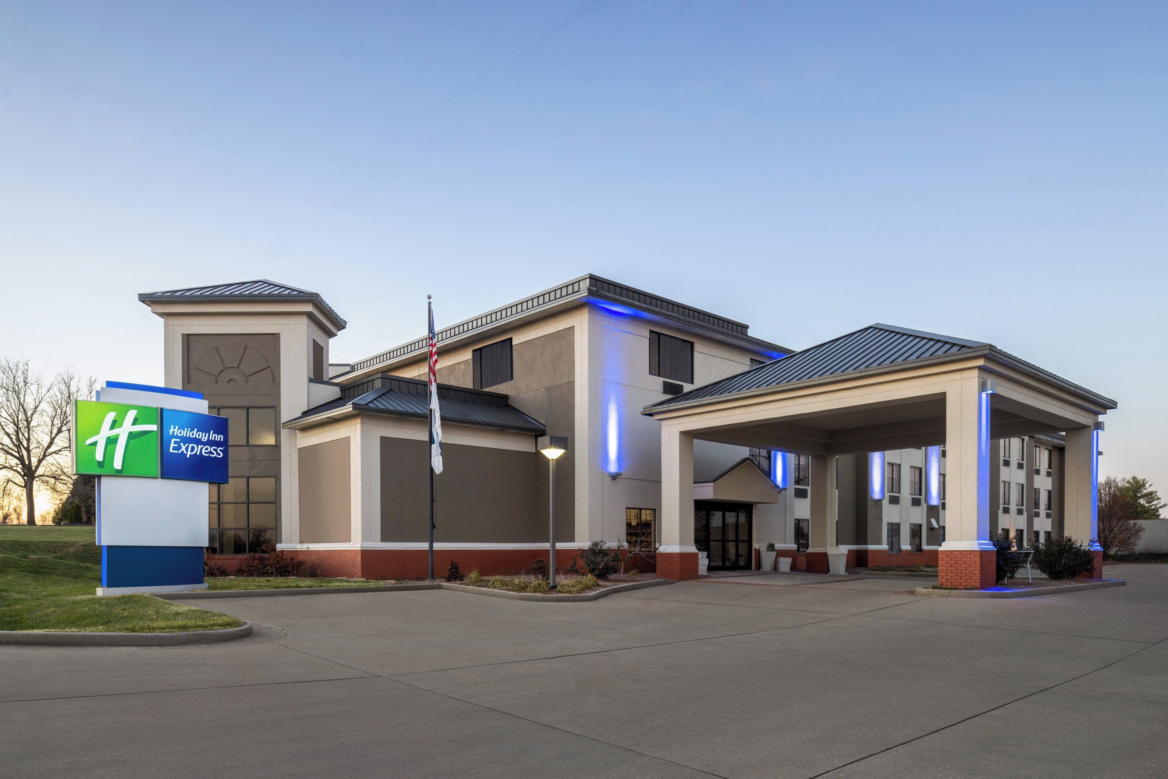 A Holiday Inn Express hotel with a covered parking area and a sign indicating the hotel's name.