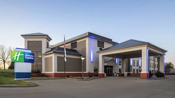 A Holiday Inn Express hotel with a covered parking area and a sign indicating the hotel's name.