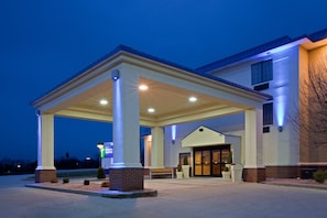 A hotel entrance with a covered outdoor area, a sign for Holiday Inn Express, and a brick facade. - Holiday Inn Express Washington by IHG (Washington)