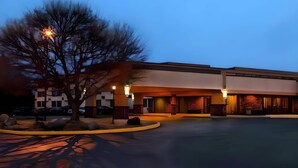 A hotel with a modern design, featuring a large parking lot and a well-lit entrance. - Quality Inn West Lafayette - University Area (West Lafayette)