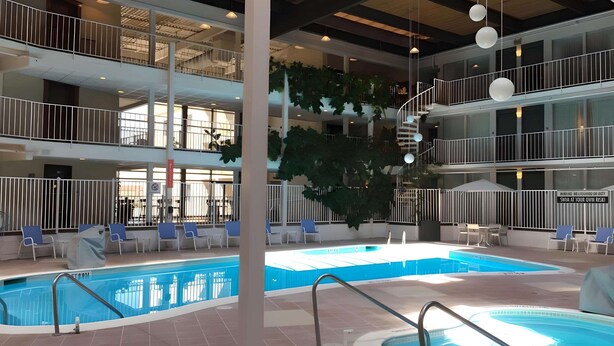 An indoor swimming pool with multiple levels, seating areas, and a staircase. - Quality Inn West Lafayette - University Area (West Lafayette)