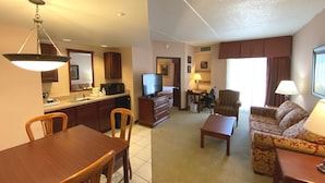 A hotel room with a dining area, kitchenette, sofa, and a TV. - Quality Inn West Lafayette - University Area (West Lafayette)