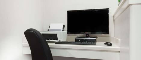 A modern office desk with a computer, keyboard, mouse, and printer.