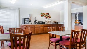 Uma cozinha moderna com armários de madeira, uma mesa de jantar com cadeiras e um balcão para refeições rápidas.