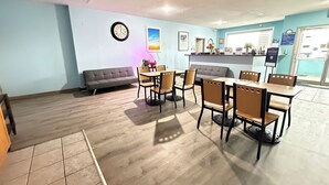 A dining area with a sofa, wooden chairs, and a table. - Days Inn by Wyndham Seymour (Seymour)