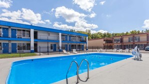 A swimming pool with two metal ladders, surrounded by a concrete deck. - Days Inn by Wyndham Seymour (Seymour)