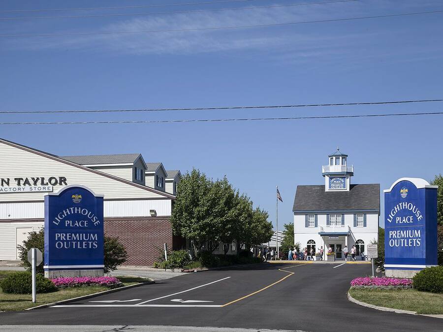 Un edificio con un letrero que indica 'Lighthouse Place Premium Outlets' y 'Ann Taylor Factory Store'.