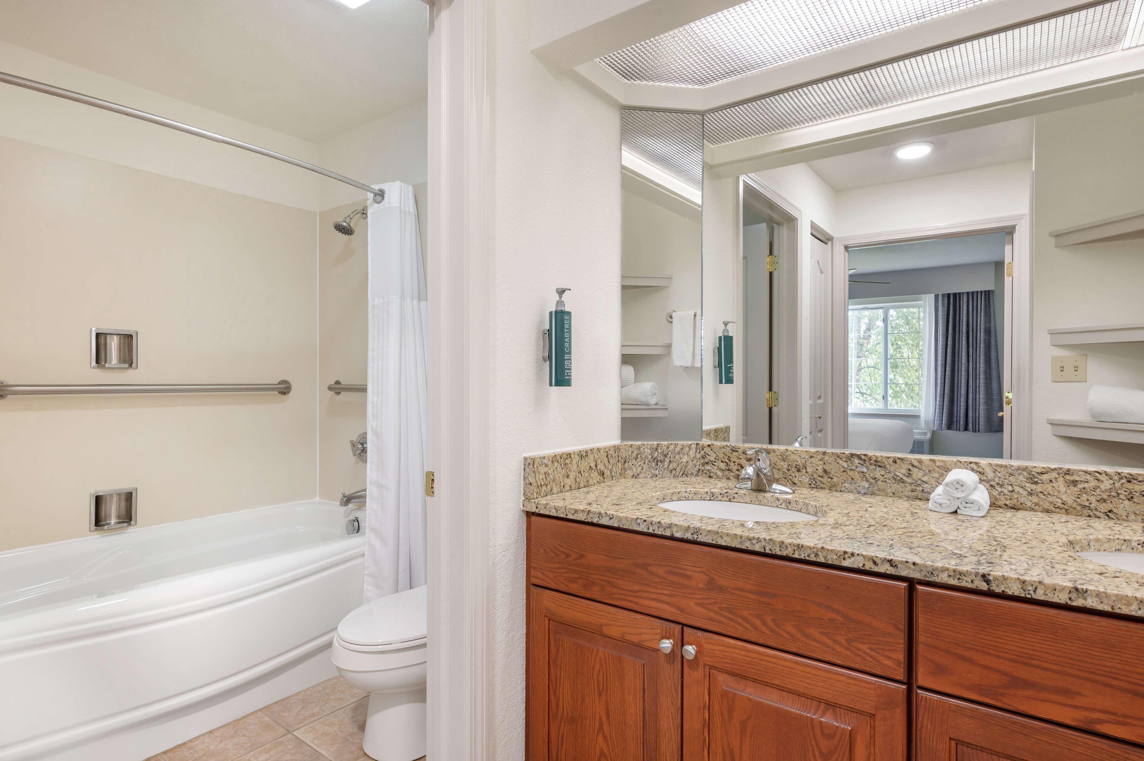 1 bedroom king suite with balcony | bathroom | combined shower/bathtub, designer toiletries, hair dryer, towels