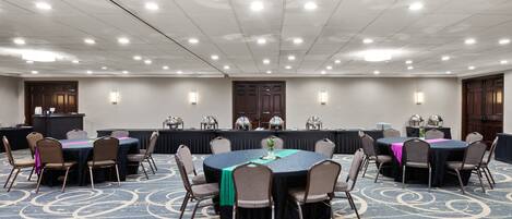 A conference room with a round table, chairs, a podium, and a carpeted floor.
