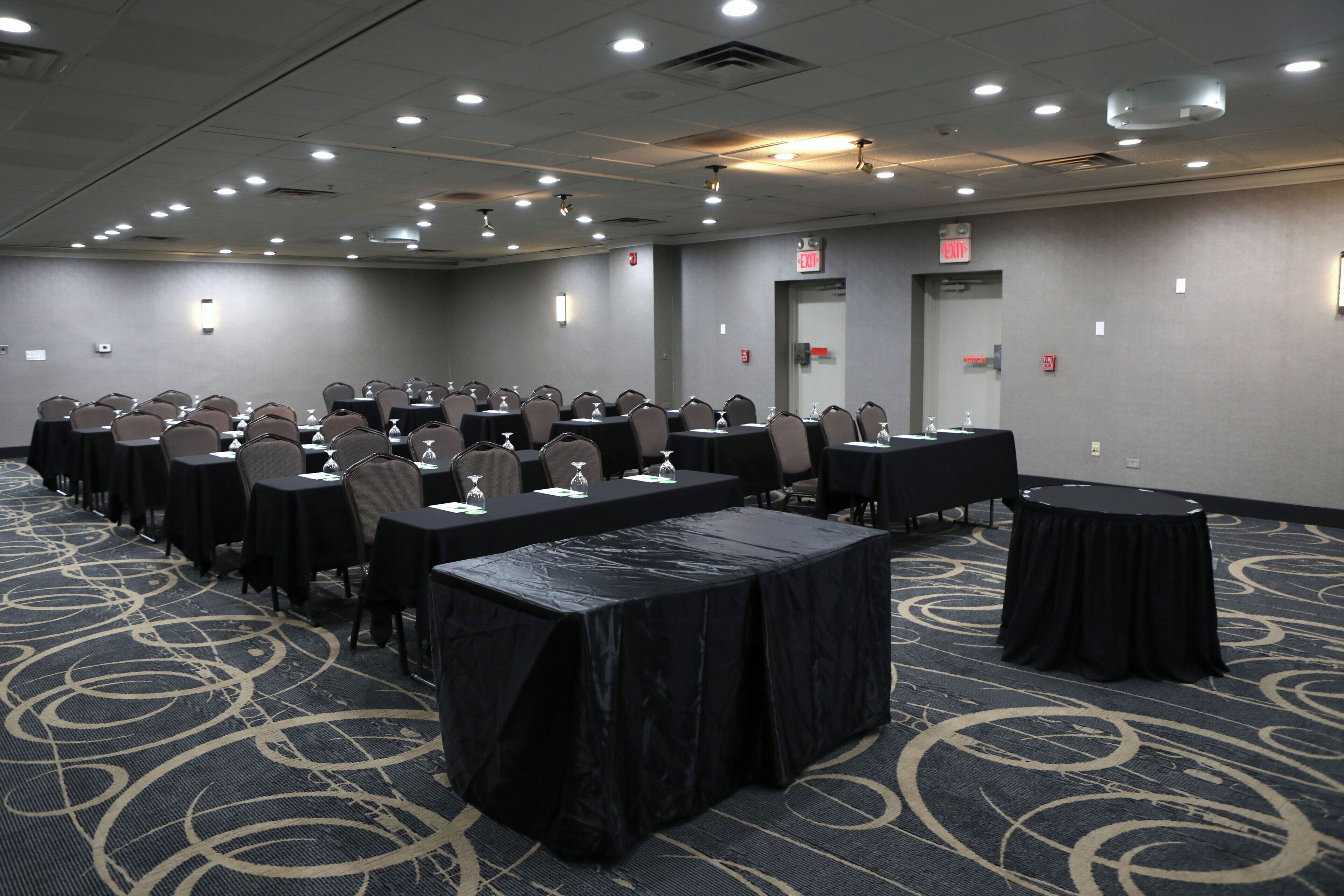 A conference room with tables and chairs, equipped with water glasses and nameplates.