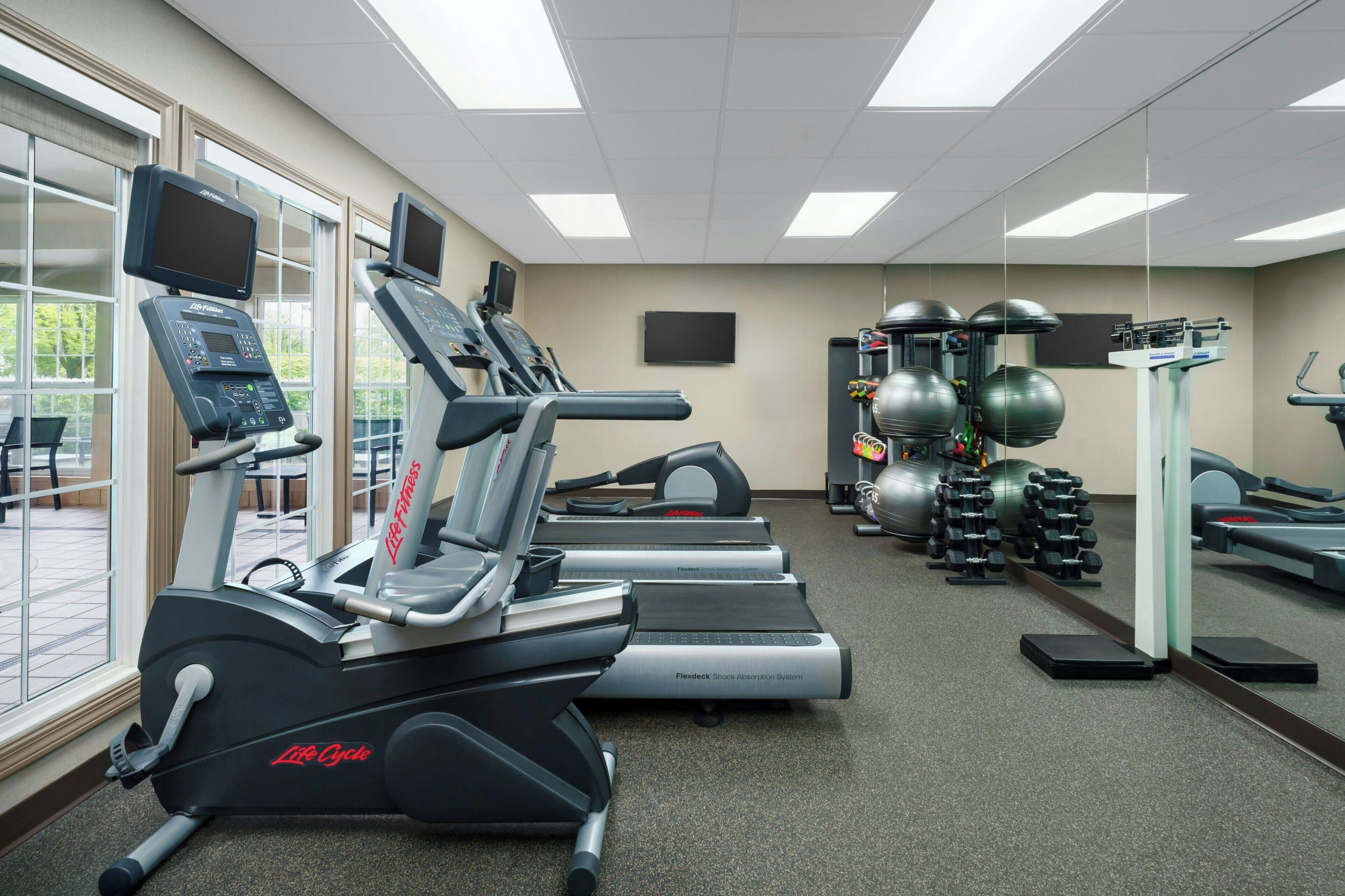 A gym with treadmills, elliptical machines, and free weights.