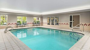 A swimming pool with clear blue water, tiled floor, and a tiled wall with a red and beige pattern. - Residence Inn by Marriott Portland Scarborough (Scarborough)