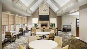 A hotel lobby with a fireplace, multiple seating areas, and a large TV screen. - Residence Inn by Marriott Portland Scarborough (Scarborough)