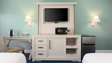 Habitación de hotel con dos camas, un escritorio, un televisor de pantalla plana, un microondas y un refrigerador.