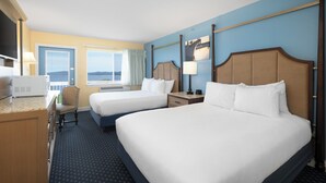 A hotel room with two beds, a desk with a microwave, a chair, a window with curtains, and a view of the outdoors. - Fireside Inn & Suites - Belfast (Belfast)
