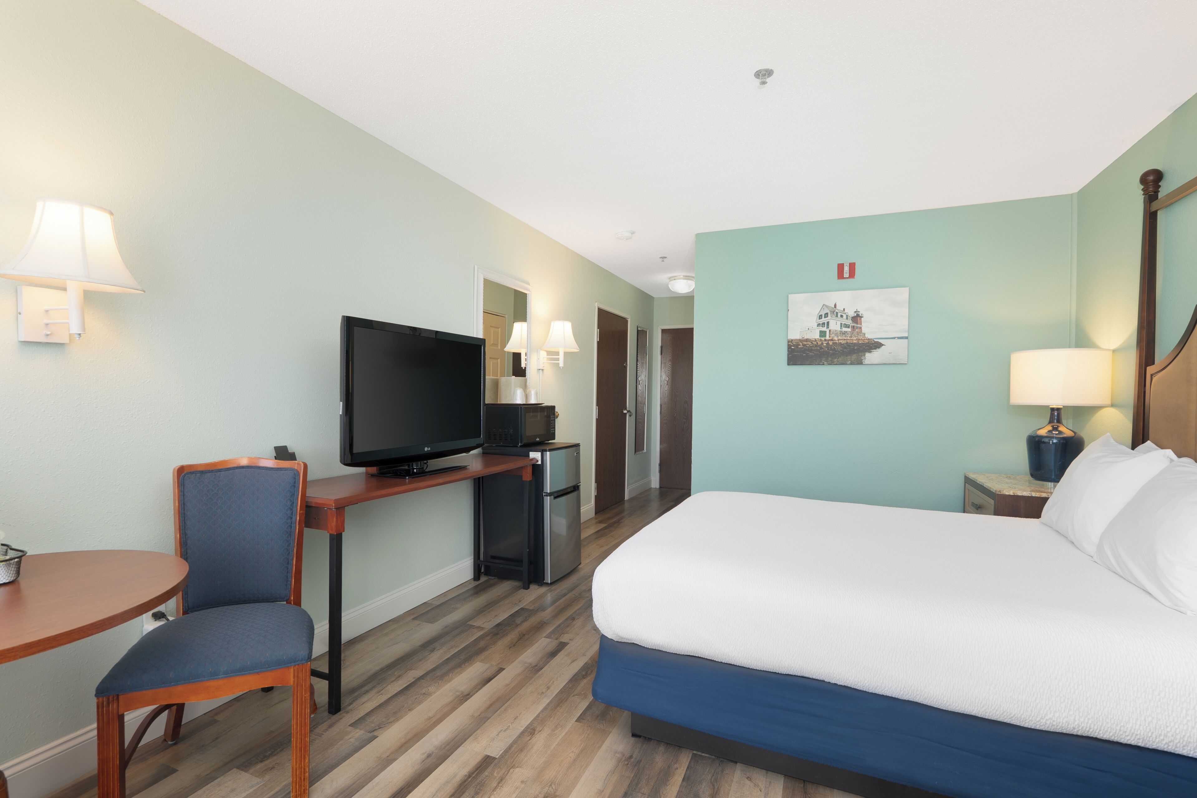 Habitació d'hotel amb un llit, una televisió, una taula i una cadira.