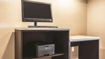 A desk with a monitor, keyboard, and printer.