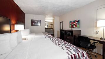 Habitación de hotel con una cama grande, un escritorio, una silla, un televisor y un baño visible a través de una puerta abierta.