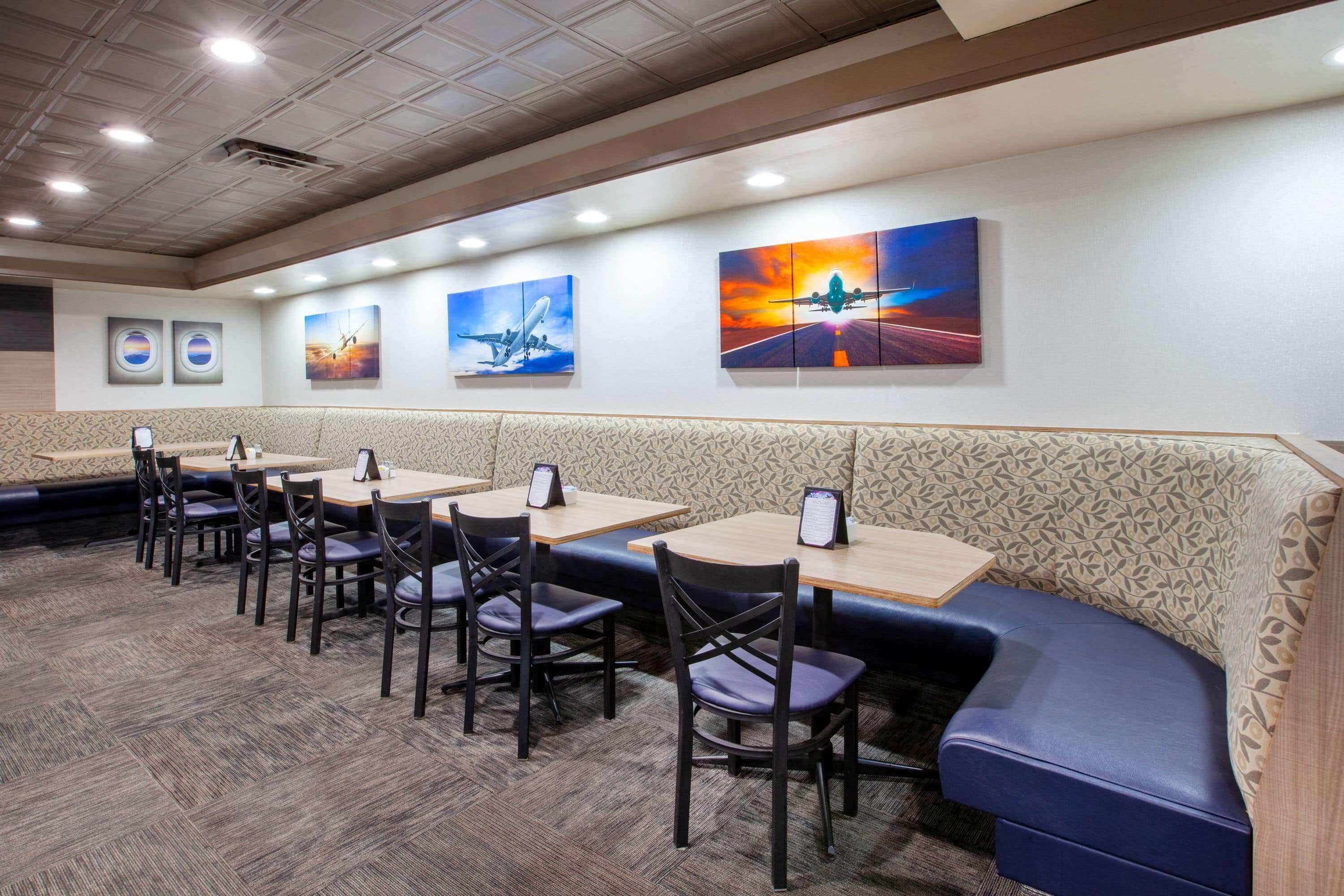 A restaurant with booths and tables, featuring artwork on the walls.