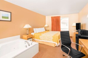 A hotel room with a bed, a desk, a chair, a television, a lamp, a picture on the wall, and a window with curtains. - Days Inn by Wyndham Worthington (Worthington)