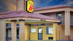 Un hôtel reconnaissable à son grand panneau « Super 8 », à un panneau indiquant une hauteur libre de 9 pieds et à un balcon doté d’une balustrade.