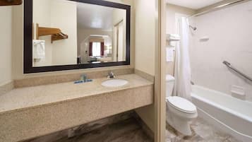Une salle de bain équipée d’un lavabo, d’un miroir, de toilettes et d’une baignoire.