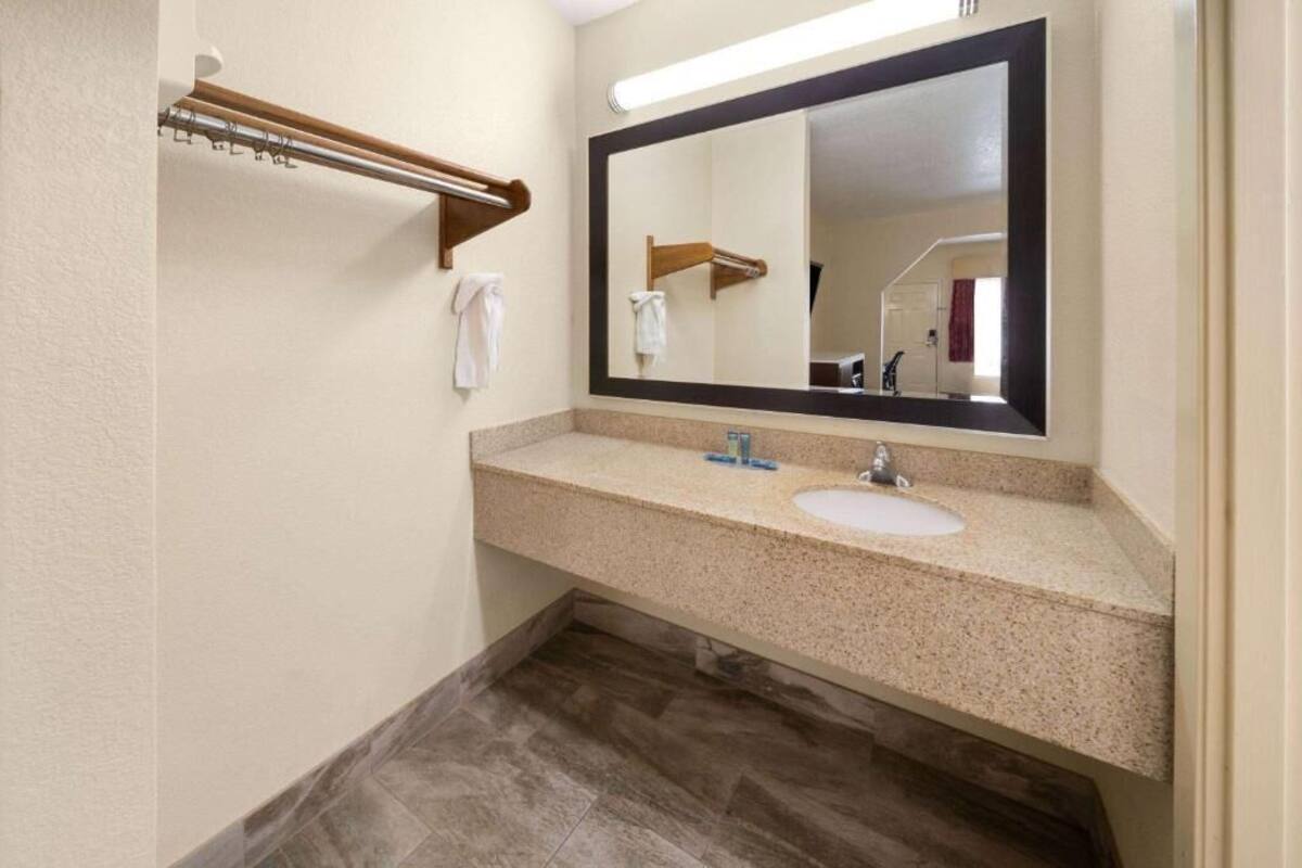 A bathroom with two sinks, a large mirror, and a towel rack.