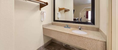A bathroom with two sinks, a large mirror, and a towel rack.