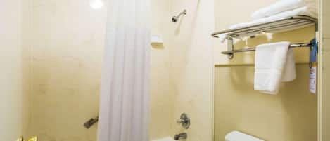 A bathroom with a bathtub, shower, toilet, and towel rack.