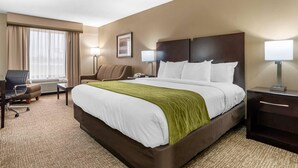 A hotel room with a large bed, a desk, a chair, and a lamp. - Comfort Inn Pearl-Jackson (Pearl)