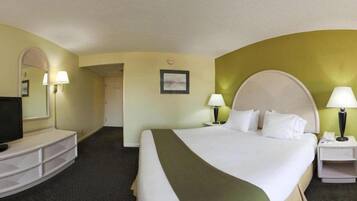 Quarto de hotel com uma cama grande, televisão, escrivaninha e uma cadeira.