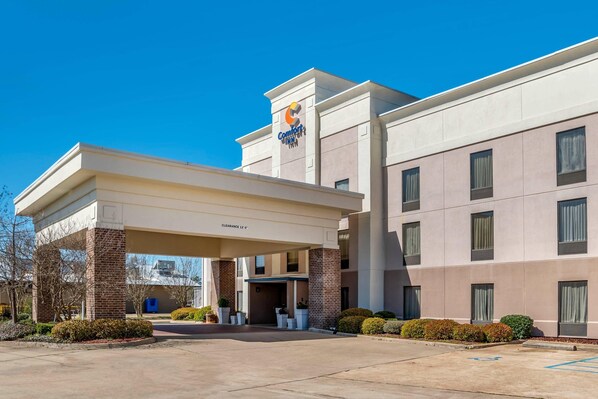 A Comfort Inn hotel with a covered entrance, clear signage, and a parking area.
