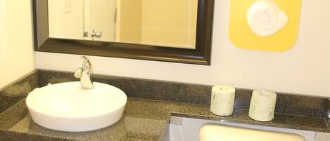 A bathroom with a sink, toilet, and a mirror above the sink.