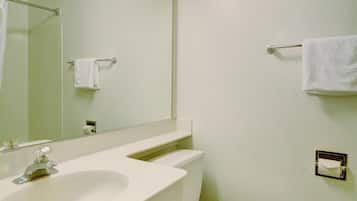Un baño con lavamanos, espejo y retrete blanco.