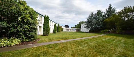 A well-maintained grassy area with a pathway leading to a row of white buildings.