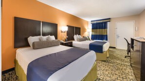 A hotel room with two beds, a desk, and a wardrobe.