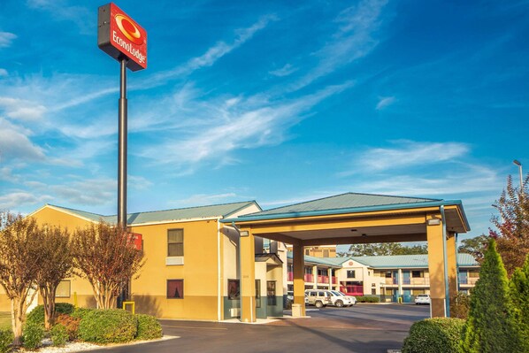 A motel with a covered parking area, a sign for EconoLodge, and a building with multiple balconies.
