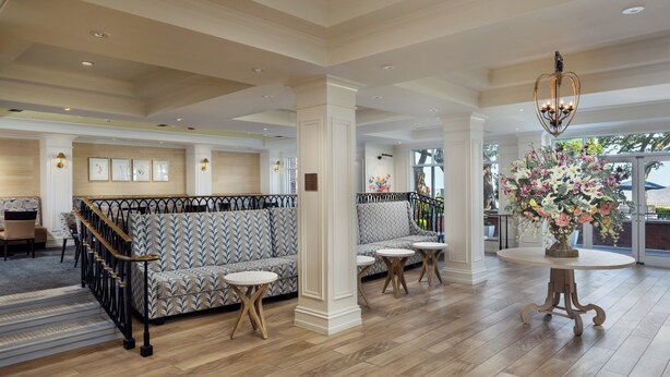 A spacious lobby with a patterned sofa, round tables, and a decorative chandelier. - The Inn at Long Beach (Long Beach)