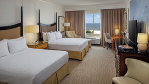 A hotel room with two beds, a desk, a chair, and a television. - The Inn at Long Beach (Long Beach)