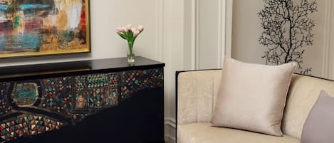 A living room with a sofa, a decorative cabinet, and a wall-mounted tree branch decoration.