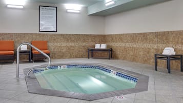 Un espace bien-être comprenant un jacuzzi, des sièges et un panneau indiquant les règles d’utilisation du spa.