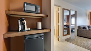 A compact kitchenette with a microwave, coffee maker, and refrigerator.