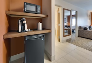 A compact kitchenette with a microwave, coffee maker, and refrigerator.