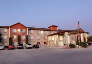 A multi-story hotel with a parking lot and an American flag.